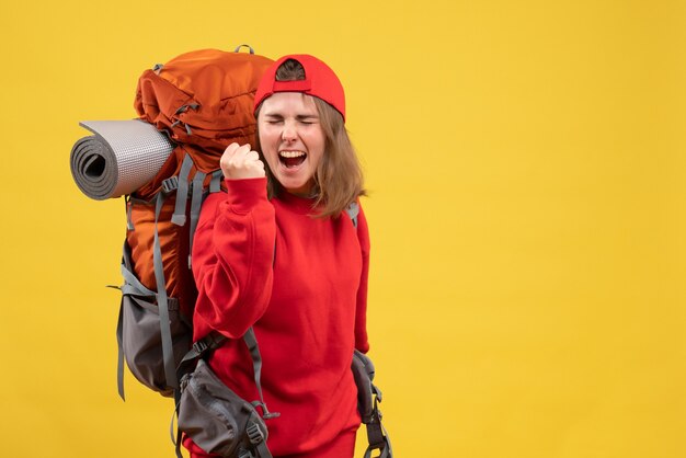 Vorderer Blick junger weiblicher Reisender mit Rucksack, der ihr Glück ausdrückt