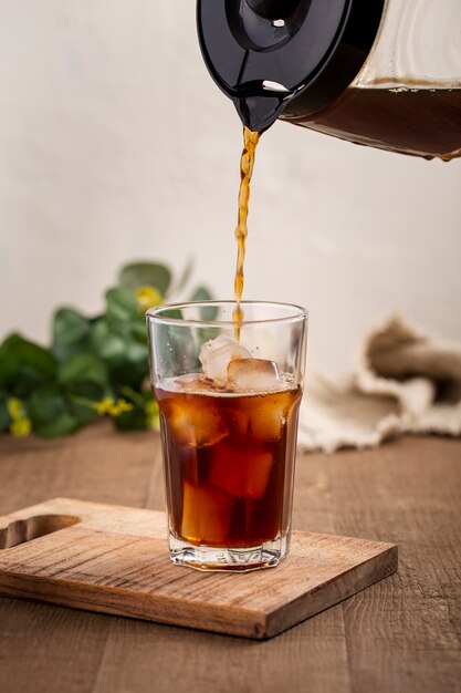 Vorne vie Kaffee in hohes Glas gegossen