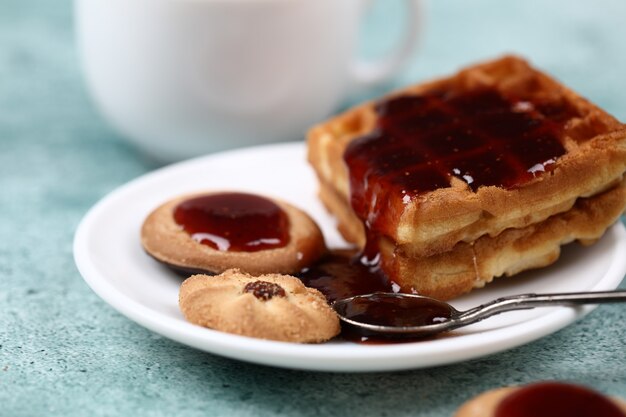 Waffel, Kekse und ein Löffel rote Marmelade.