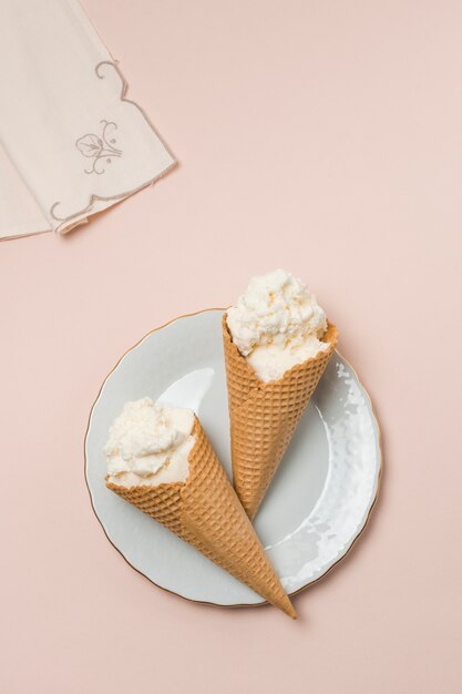 Waffelkegel mit Eiscreme auf Platte nahe Serviette