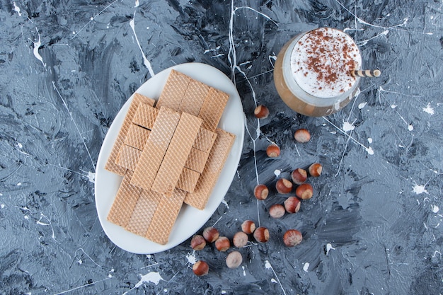 Waffelsticks mit Macadamianüssen und einer Glasschale leckeren heißen Kaffees.