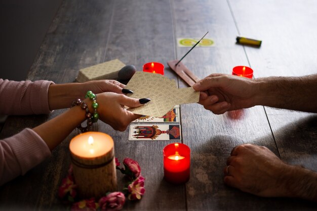 Wahrsagerin liest eine Zukunft durch Tarotkarten auf rustikalem Tisch