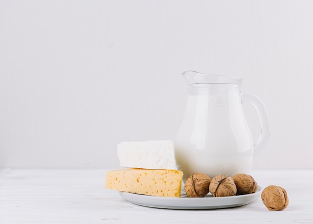 Walnüsse; Glas Milch und Käse auf weißem Hintergrund