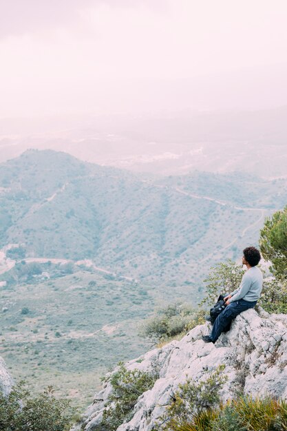 Wanderer, der auf Felsen sitzt