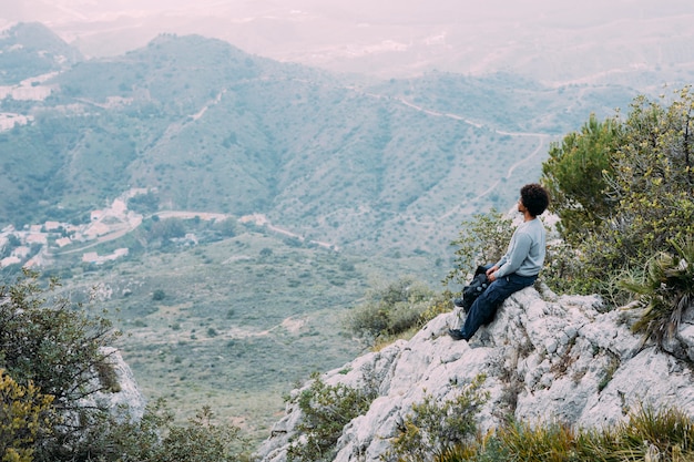 Kostenloses Foto wanderer, der auf felsen sitzt