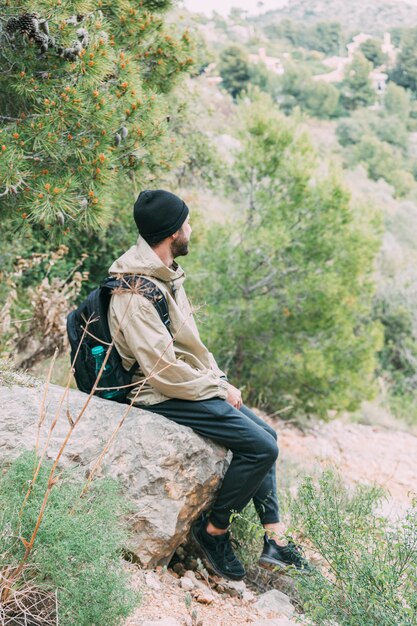 Wanderer, der auf Felsen sitzt