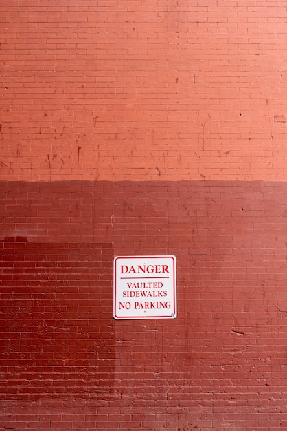 Warnzeichen auf Vorderansicht der Backsteinmauer