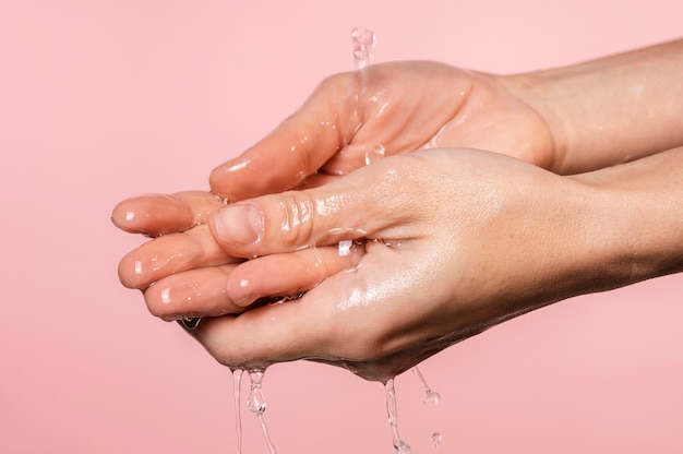 Wasser goss auf die Hände der Frau Nahaufnahme