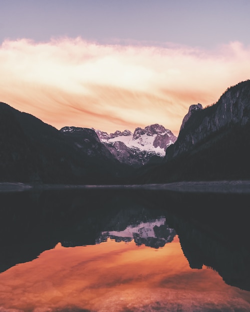 Wasser reflektiert das Ufer, umgeben von Bergen unter einem schönen Himmel