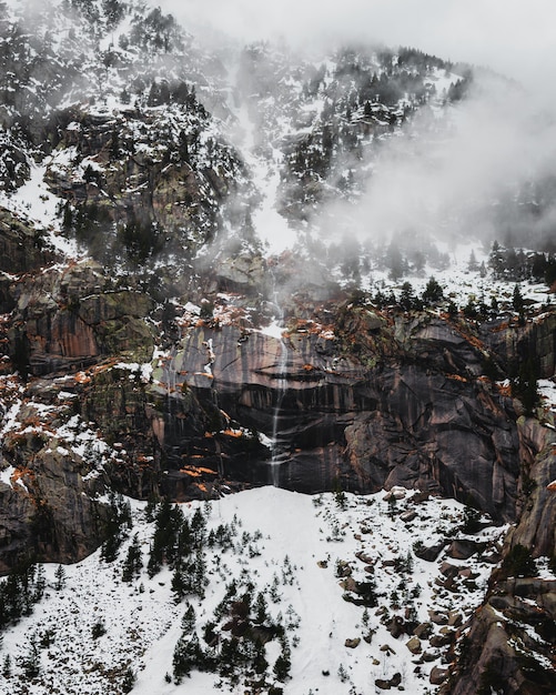 Kostenloses Foto wasserfall in den bergen mit schnee