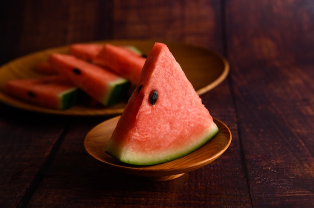 Wassermelone in Stücke geschnitten in einer Schüssel auf einem Holztisch.