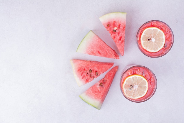 Kostenloses Foto wassermelonensaft mit roten fruchtscheiben auf weiß.