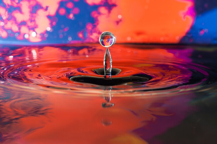 Kostenlose Foto wasseroberfläche mit tropfen und buntem hintergrund
