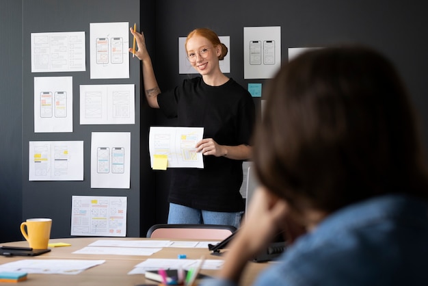 Kostenloses Foto webdesignerin mit papieren und notizen im büro