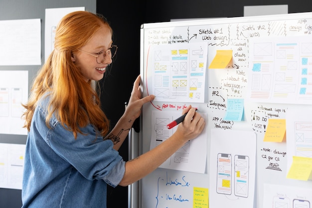 Kostenloses Foto webdesignerin mit papieren und notizen im büro