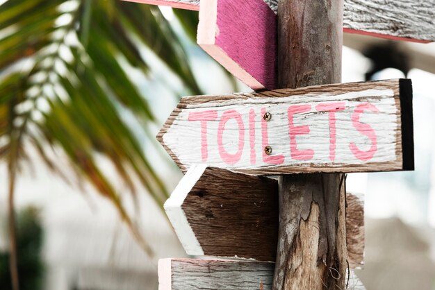 Wegweiser aus Holz zu den Toiletten