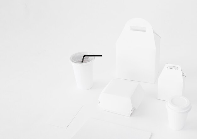Wegwerfschalen- und -nahrungsmittelpakete auf die weiße Tischplatte