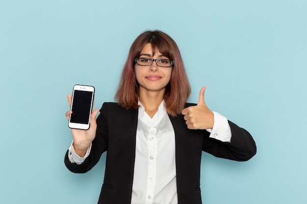 Weibliche Büroangestellte der Vorderansicht, die ihr Telefon auf der blauen Oberfläche hält