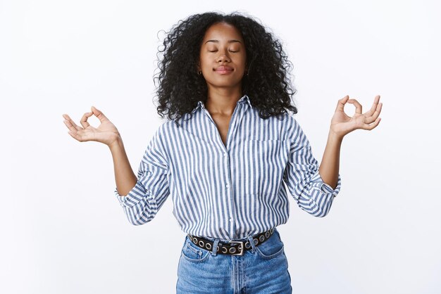 Weibliche Büroangestellte, die während des Mittagessens meditieren, halten Gefühle unter Kontrolle, machen Atemübungen Yoga