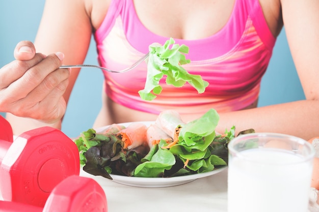 Kostenloses Foto weibliche fitness essen frischen salat und milch, gesunde lebensweise konzept