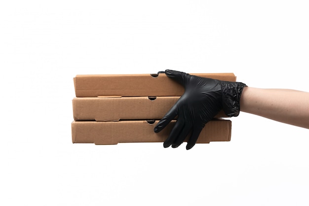 Weibliche Hände einer Vorderansicht in schwarzen Handschuhen, die Lieferkästen auf Weiß halten