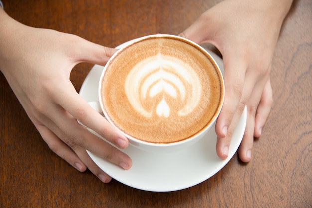 Weibliche Hände halten Kaffeetasse