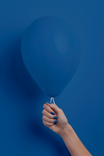 Weibliche Hand, die Ballon hält