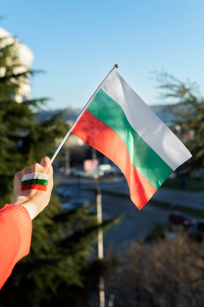 Weibliche hand, die stoffflagge von bulgarien hält