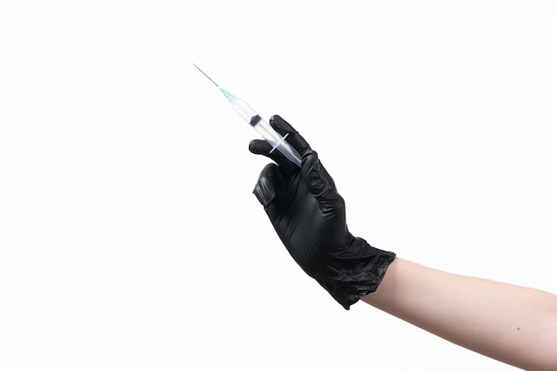 Weibliche Hand einer Vorderansicht im schwarzen Handschuh, der Injektion auf Weiß hält