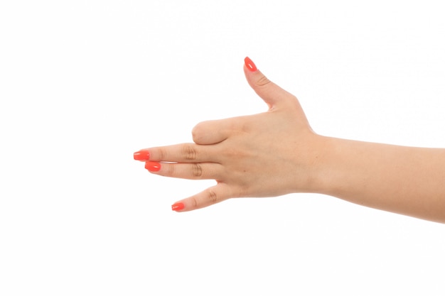 Weibliche Hand einer Vorderansicht mit farbigen Nägeln, die Zeichen auf dem Weiß zeigen
