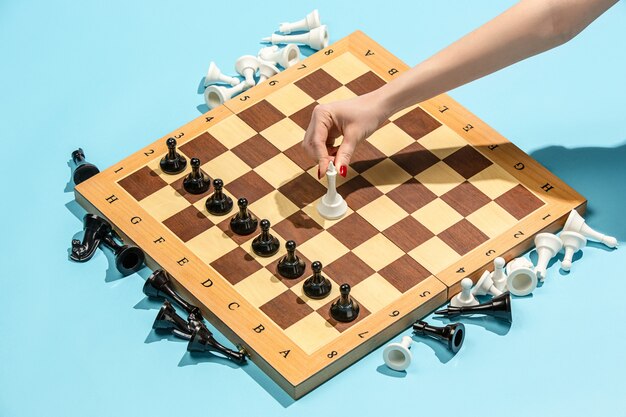 Weibliche Hand und Schachbrett, Spielkonzept.