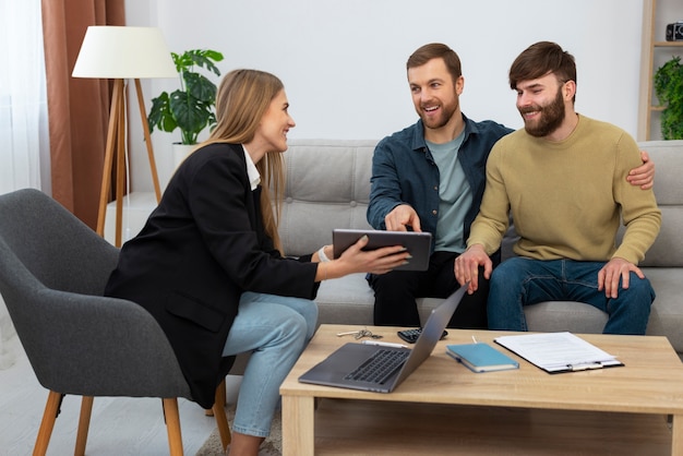 Weibliche Immobilienmaklerin spricht Geschäfte und zeigt dem schwulen Paar das Haus.