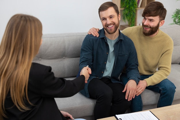 Weibliche Immobilienmaklerin spricht Geschäfte und zeigt dem schwulen Paar das Haus.