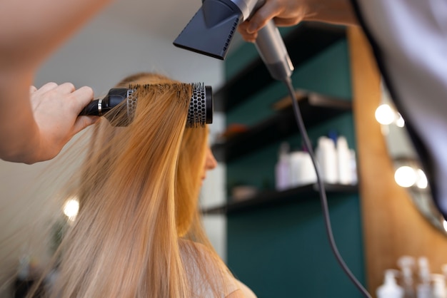 Weibliche Klientin beim Friseur, die sich die Haare macht