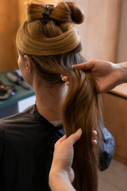 Kostenloses Foto weibliche klientin beim friseur, die sich die haare macht