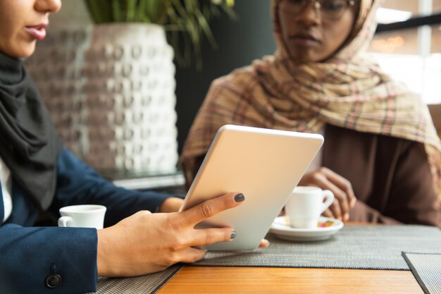 Weibliche Kollegen, die Inhalt auf Tablette aufpassen