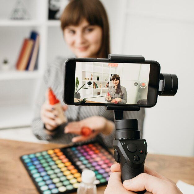 Weibliche Make-up-Bloggerin mit Streaming mit Smartphone