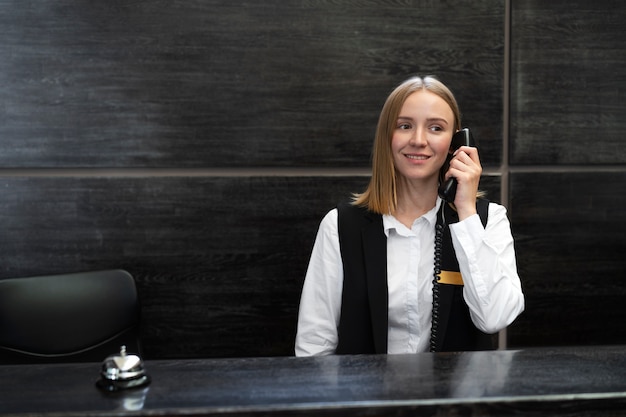 Kostenloses Foto weibliche rezeptionistin im eleganten anzug während der arbeitszeit