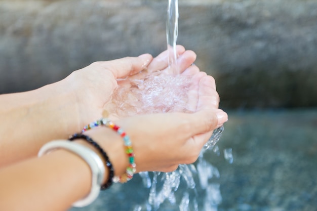 Weibliche Sammeln von Wasser in den Händen