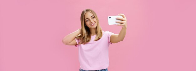 Kostenloses Foto weibliche schönheitsbloggerin macht ein selfie und veröffentlicht ein neues online-porträt einer charmanten, gebräunten jungen frau in