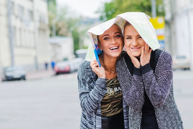 Weibliche Touristen mit Karte auf Kopf