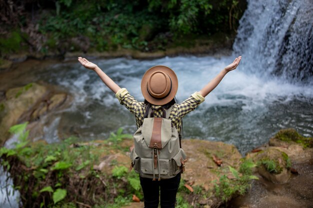Weibliche Touristen sind glücklich und erfrischt am Wasserfall.