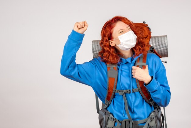 Weibliche Touristin der Vorderansicht in der Maske mit ihrem freudigen Rucksack