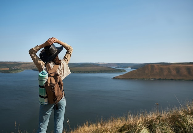 Weibliche Wanderer mit Rucksack, die Pause auf hohem Hügel machen