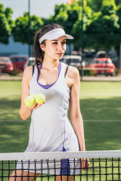 Weiblicher Athlet, der in der Hand Tennisbälle hält