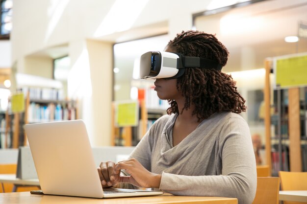 Weiblicher Bibliotheksbenutzer, der virtuelles Video aufpasst