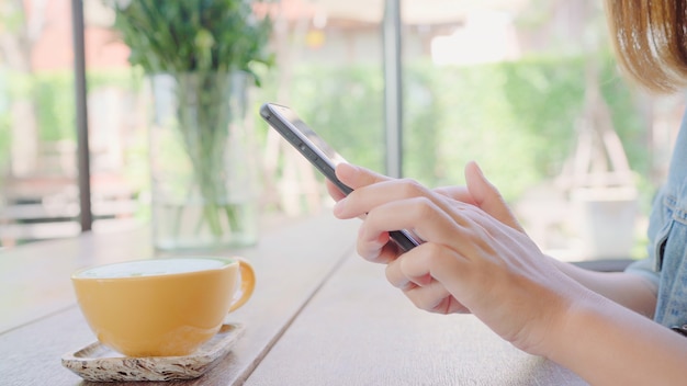 Weiblicher Blogger, der Schale des grünen Tees im Café mit ihrem Telefon fotografiert.