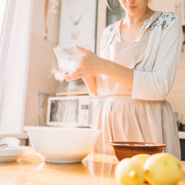 Weiblicher Chef in einer Küche bereitet Teig vom Mehl zu, um Torte zu machen