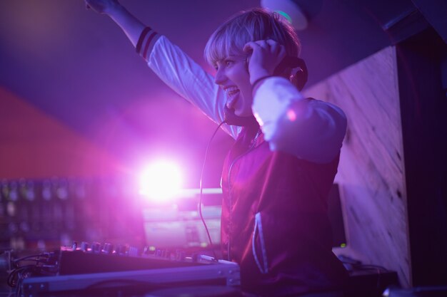 Weiblicher DJ, der Spaß beim Musikspielen in der Bar hat