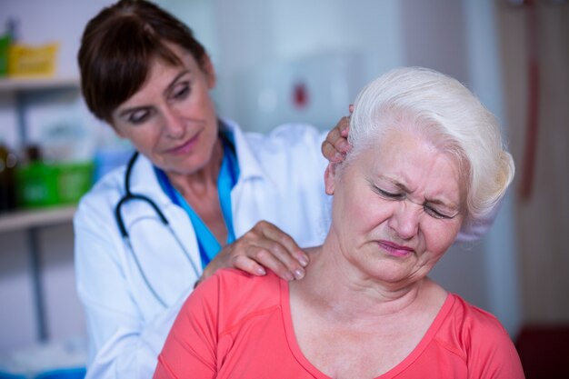 Weiblicher Doktor, der einen Patienten überprüft